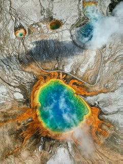 Aerial view of Grand Prismatic Spring with vivid blue center and colorful mineral bands