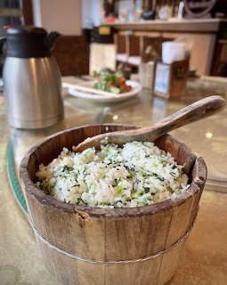 Wooden bowl filled with seasoned rice and herbs on a kitchen counter