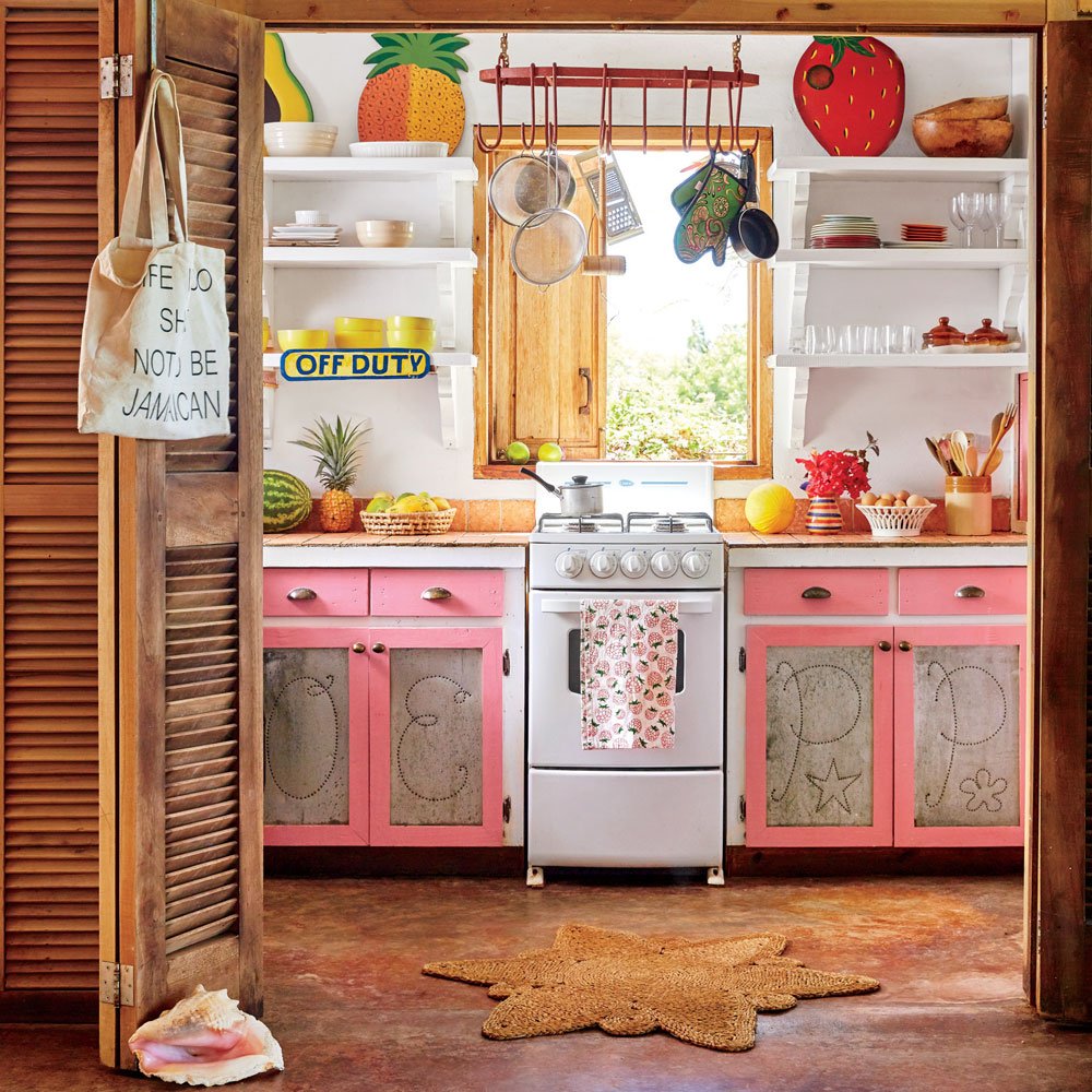 Vintage kitchen with pink cabinets, open shelves, and sunny window