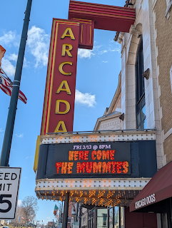 Arcada Theater marquee with colorful neon sign and movie billboard on a sunny day
