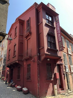 Red corner building of Museum of Innocence in Istanbul with vertical banner sign on facade