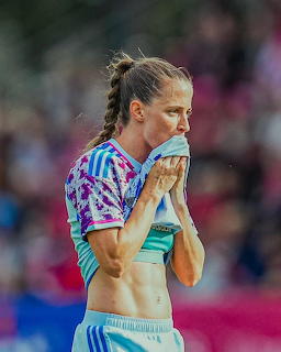 Female soccer player wiping her face with her jersey during a match