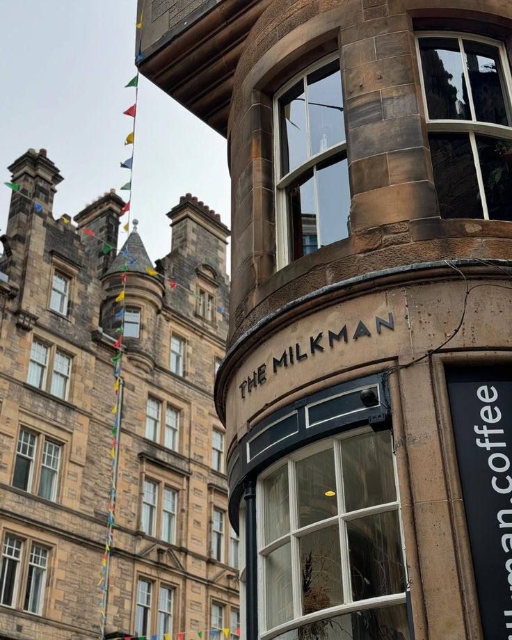 The Milkman cafe on a curved sandstone corner building in Edinburgh with bunting flags