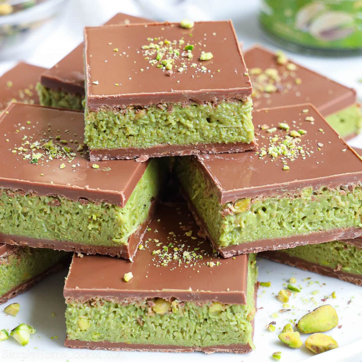 Stacked chocolate bars with green pistachio filling and crushed pistachios on top
