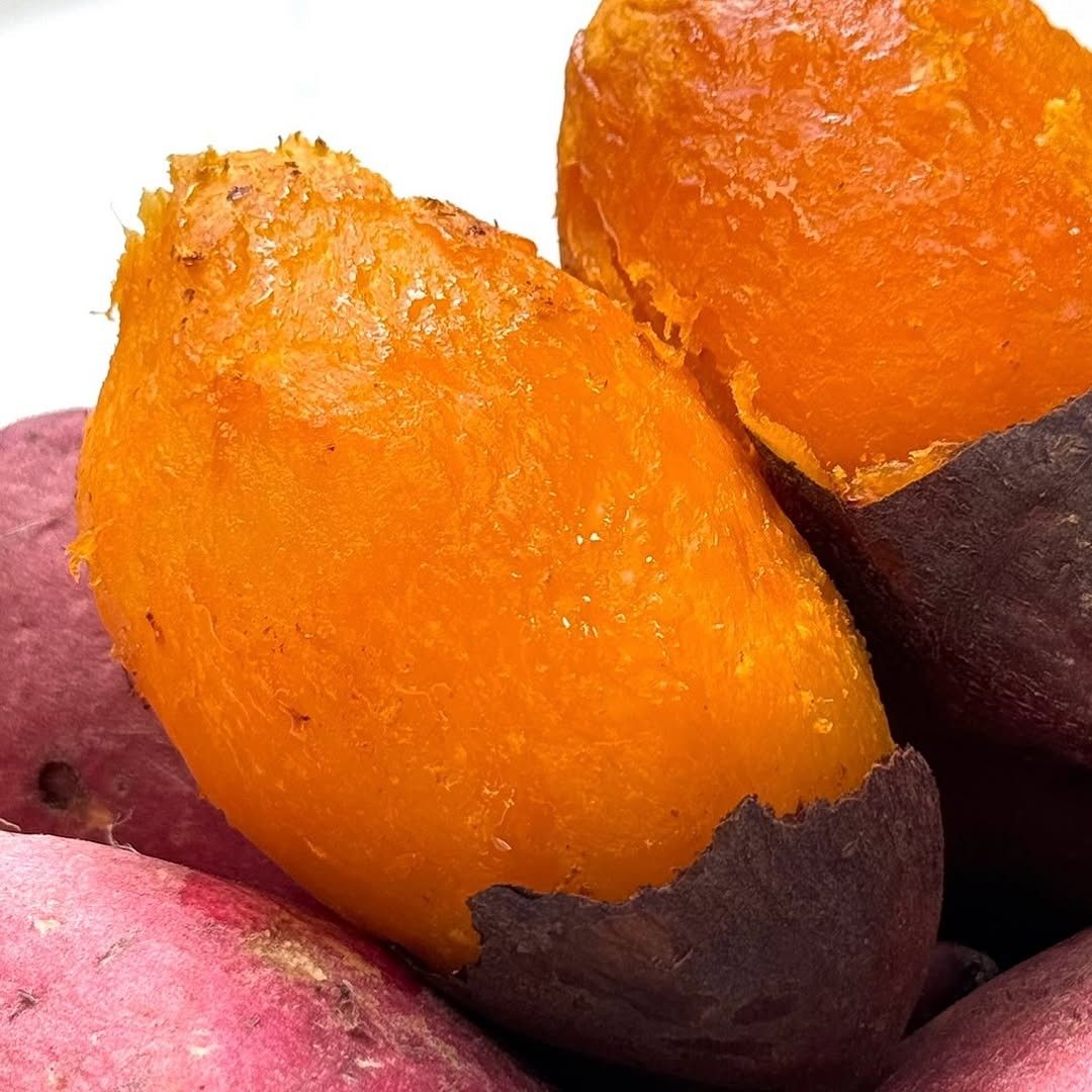 Close-up of coked sweet potatoes with bright orange flesh and purple skin