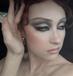 Woman with dramatic smokey eye makeup and pale skin looking at camera