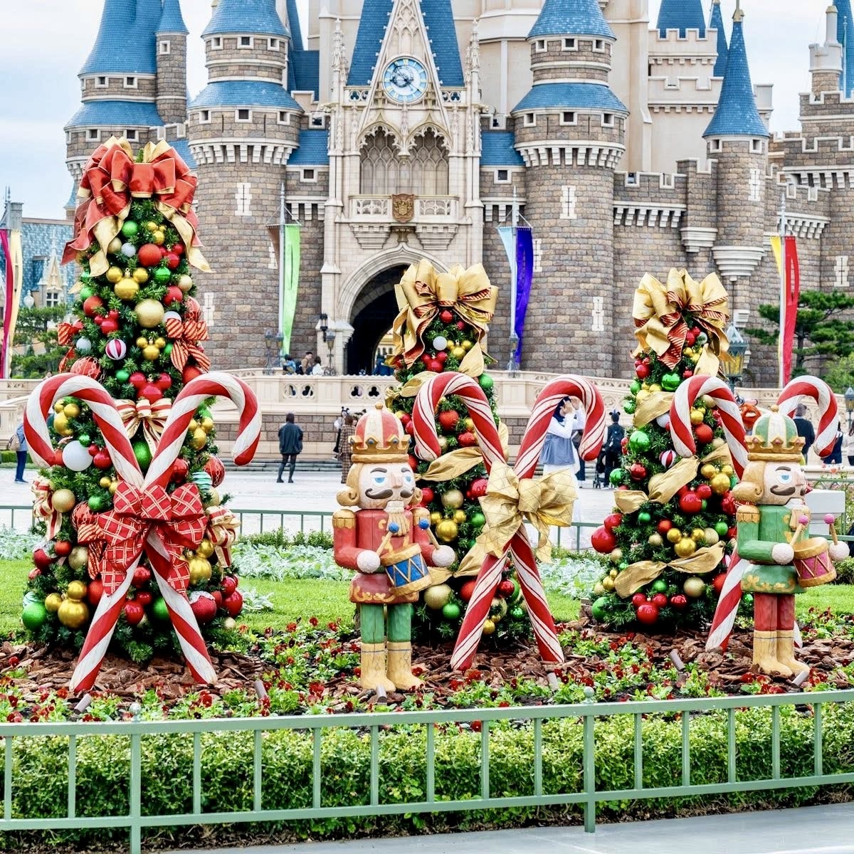 Cinderella Castle with Christmas decorations, Disney characters, candy canes, and holiday wreaths in foreground