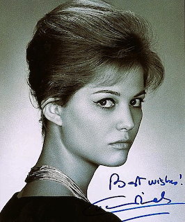 Black and white portrait of Claudia Cardinale with elegant updo hairstyle and pearl necklace, featuring autograph