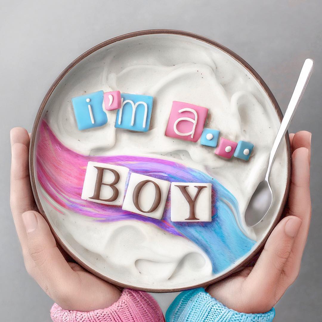 Smoothie bowl with pink and blue swirls, letter tiles reading I'm a BOY, held in hands