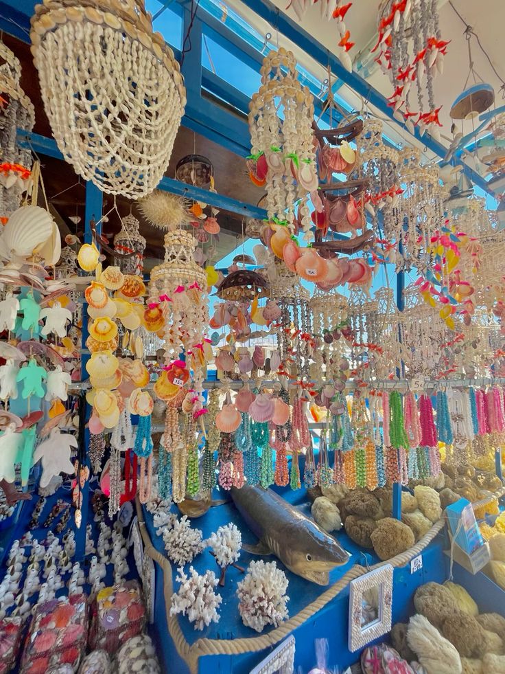 Colorful souvenir shop in Rhodes with hanging shell wind chimes, coral ornaments, and nautical decorations