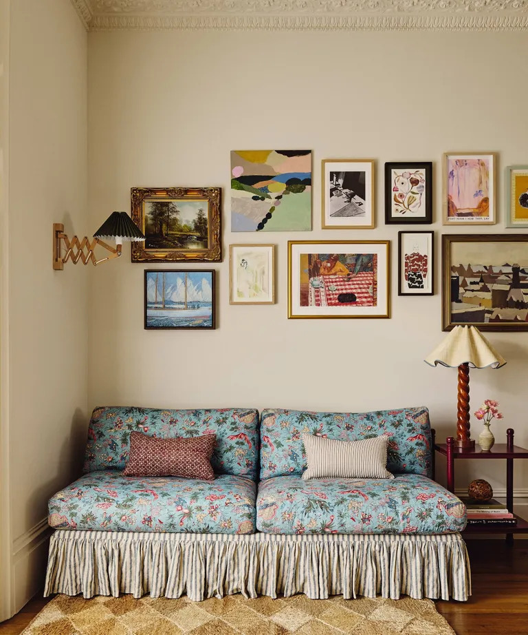 Floral blue sofa beneath a gallery wall in a cozy living room
