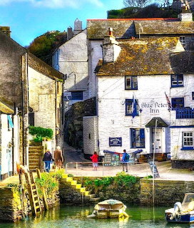 White stone buildings along waterfront in Polperro village, Cornwall, with harbor and boats