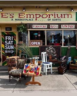 Colorful vintage emporium storefront with furniture, retro signs, and antiques displayed outside