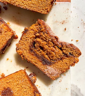 Slices of pumpkin bread with cinnamon crumb topping on parchment paper