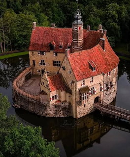 Burg Vischering medieval moated castle with stone towers reflected in surrounding water