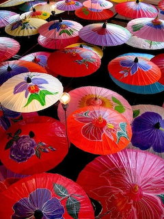 Colorful paper umbrellas with floral patterns seen from above