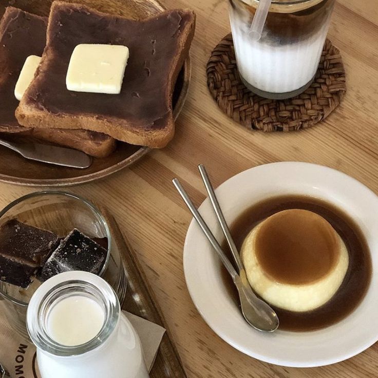 Cafe table with buttered toast, caramel purin, iced coffee, and a small bottle of milk