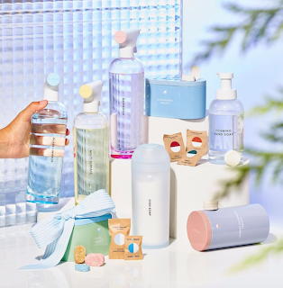 Pastel-colored cleaning bottles and containers arranged on white surface with shadow patterns