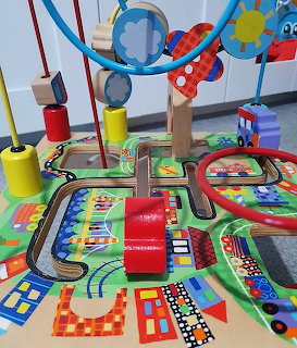 Colorful wooden baby activity cube with bead maze wires and painted road scene on top