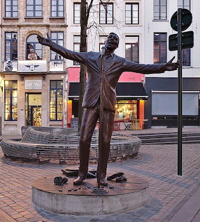 Bronze statue of Jacques Brel with arms wide open in a Brussels city square