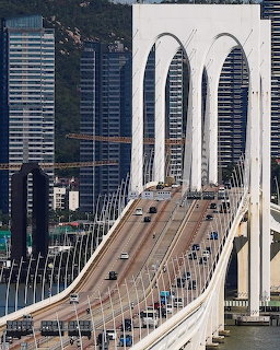 Sai Van Bridge in Macau with cars on the roadway and tall buildings in the background