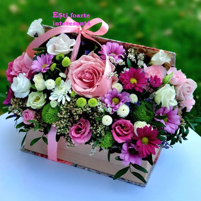 Wooden basket arrangement of pink roses and mixed flowers with ribbon