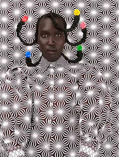 Portrait of a Black woman with colorful hair clips against a black and white optical illusion pattern background
