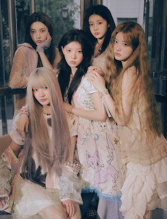 Five young women in pastel outfits posing together in a vintage-style group portrait