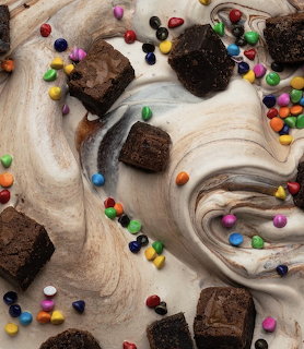 Chocolate brownies on white marble with colorful candies