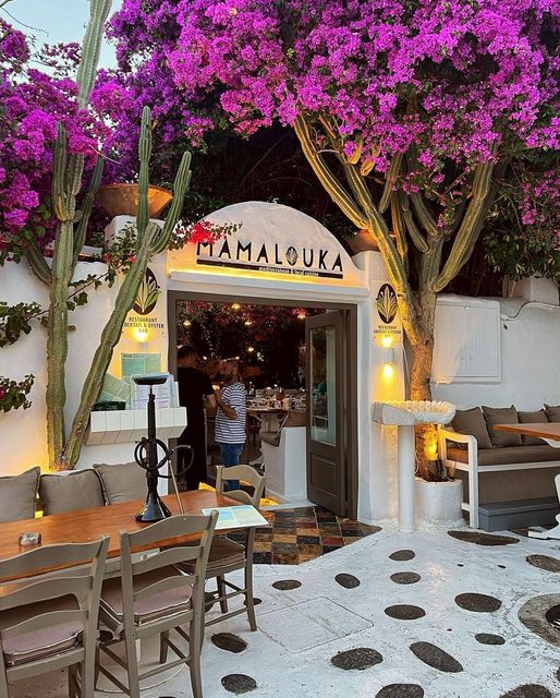 Charming Greek taverna courtyard with purple bougainvillea and white archway