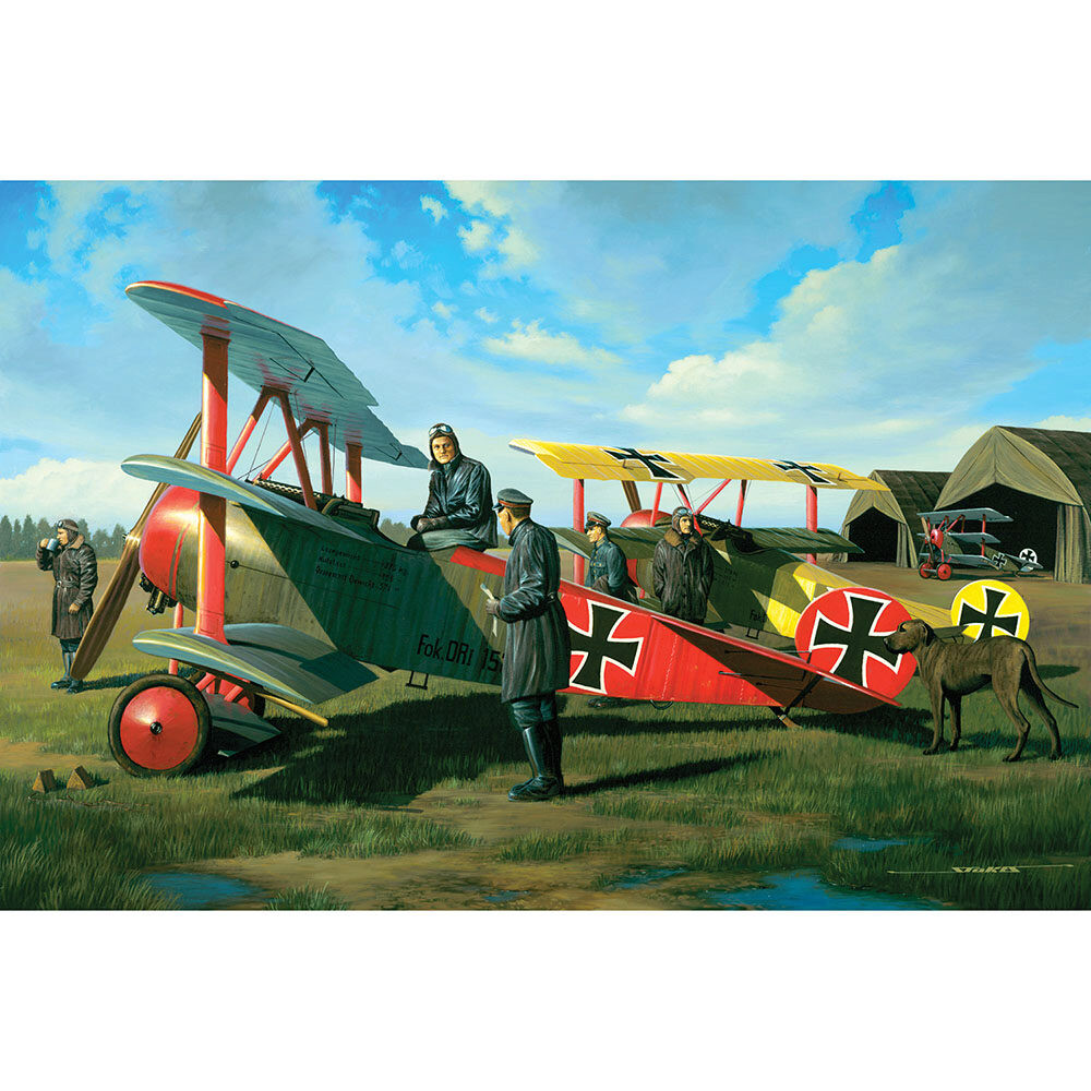 Two WWI German biplane fighters with pilots standing beside them on grass airfield