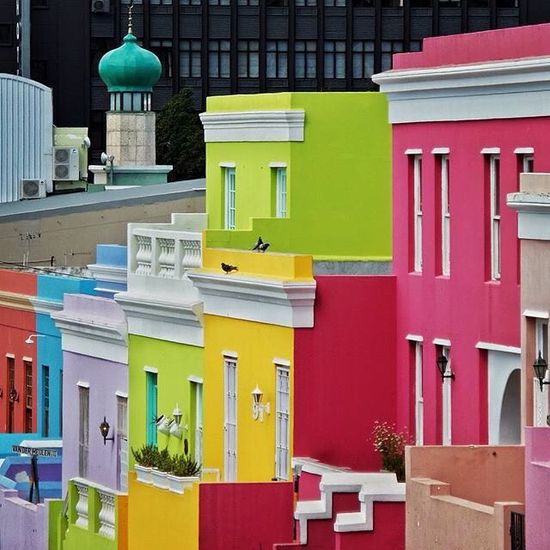 Brightly colored city buildings with pink, yellow, green, blue, and purple facades