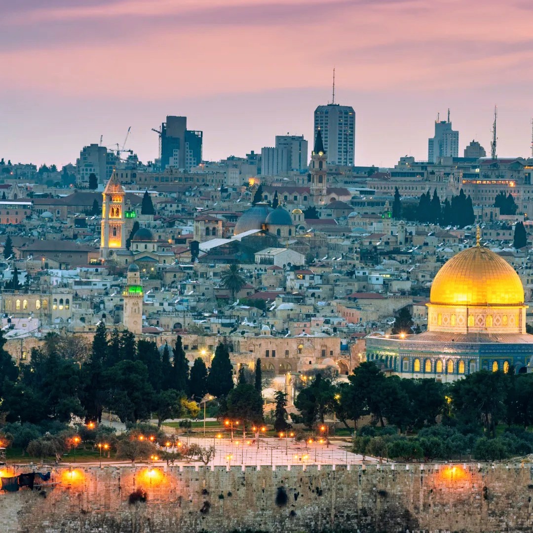 Jerusalem Old City skyline at dusk with the golden Dome of the Rock and surrounding buildings