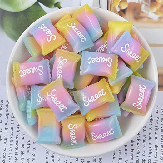 White bowl filled with pastel rainbow colored pilow-shaped candies labeled Sweet