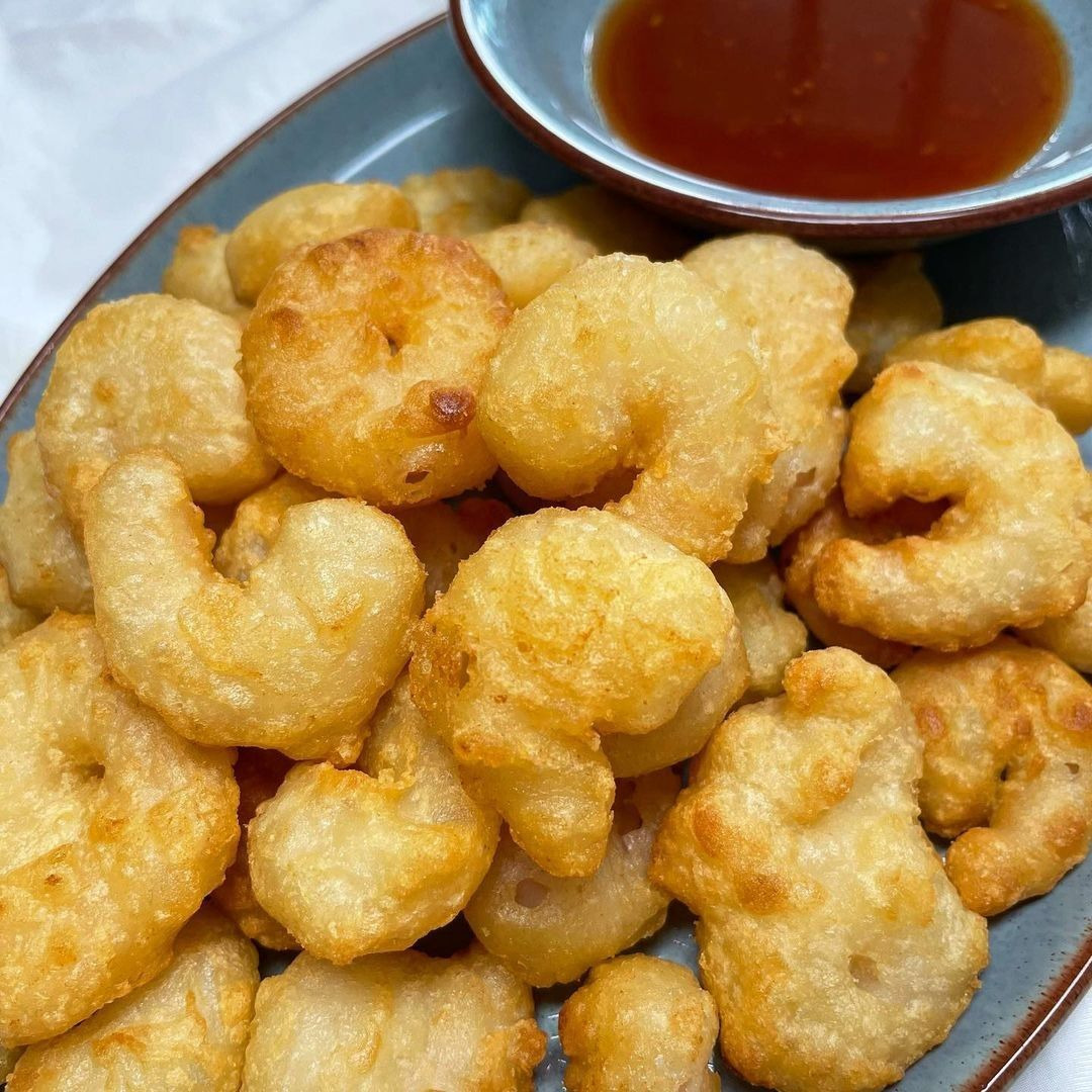 Plate of golden fried popcorn shrimp with dipping sauce