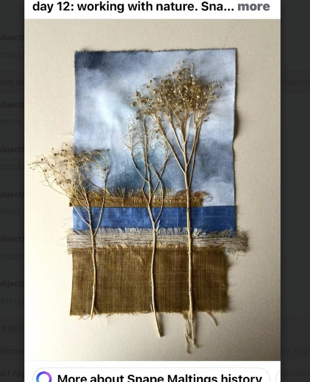 Textile wall art with dried branches and plants arranged on blue and golden fabric resembling a landscape