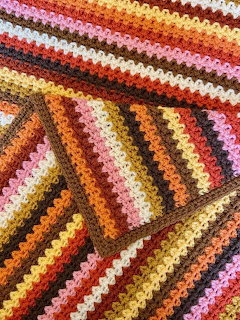 Colorful crochet blanket with diagonal granny square patterns in warm autumn colors