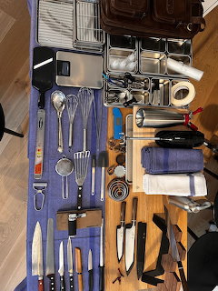 Chef cooking kit with utensils and apron arranged on a surface