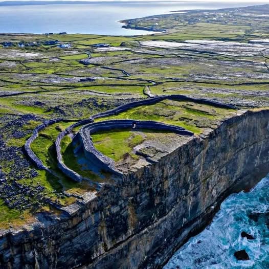Aerial view of Dún Aonghasa stone fort atop steep sea cliffs in Ireland