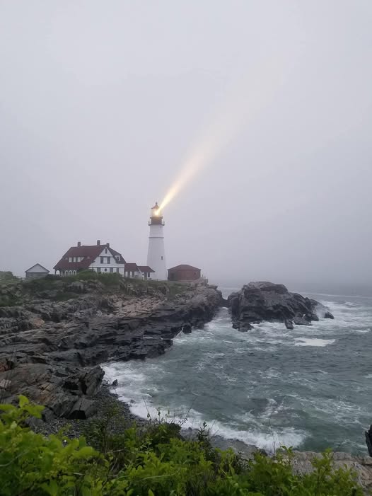 White lighthouse with keeper's house on rocky Maine coast at Cape Elizabeth.