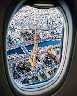 View of Eiffel Tower and Paris cityscape through airplane window