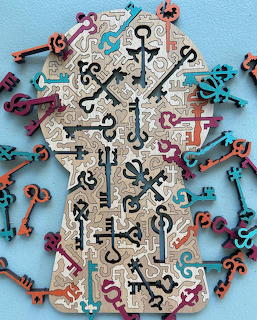 Colorful decorative vintage keys in teal, pink, orange and black arranged on a light blue background