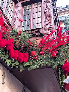 Building window with red bows and evergreen Christmas decorations