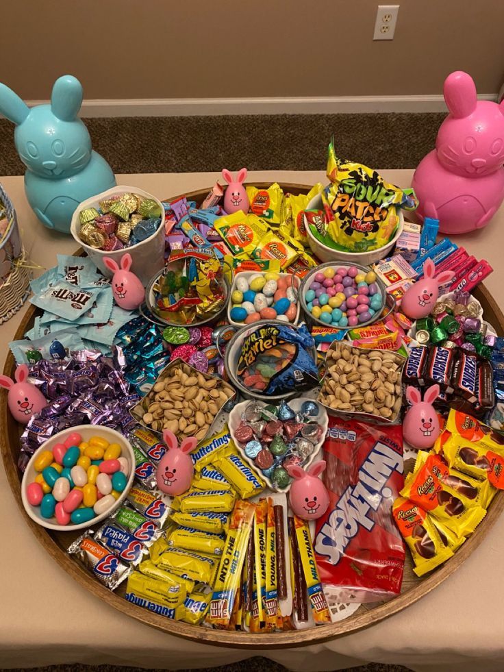 Overhead view of candy board with colorful sweets, lollipops, chocolates, and gummy candies arranged on round wooden tray