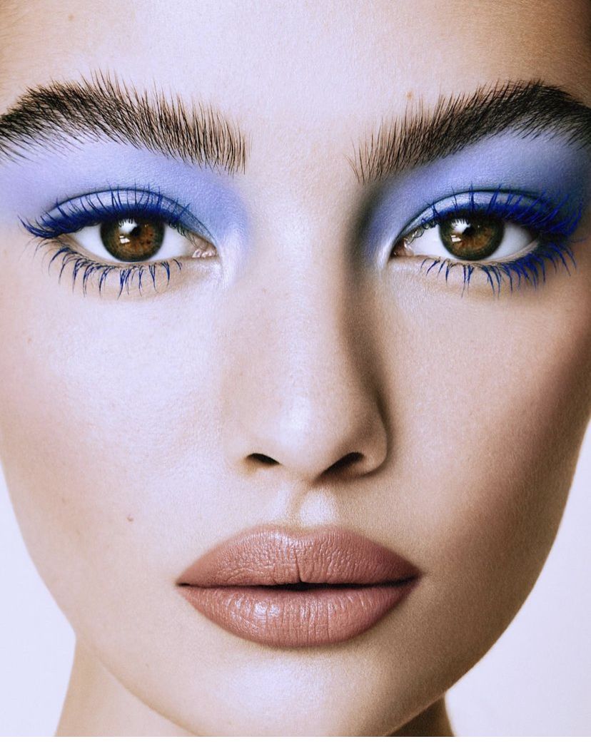 Close-up of a face wearing vivid blue eyeshadow makeup.