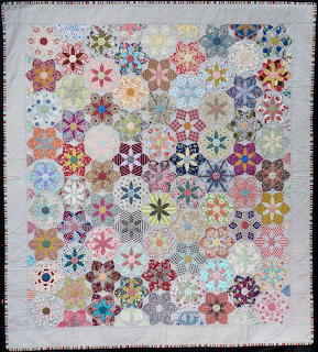 Colorful hexagonal patchwork quilt with varied floral and geometric patterns
