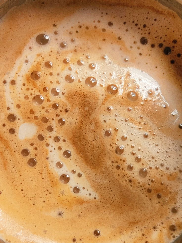 Close-up of foamy coffee surface with bubbles and creamy swirls