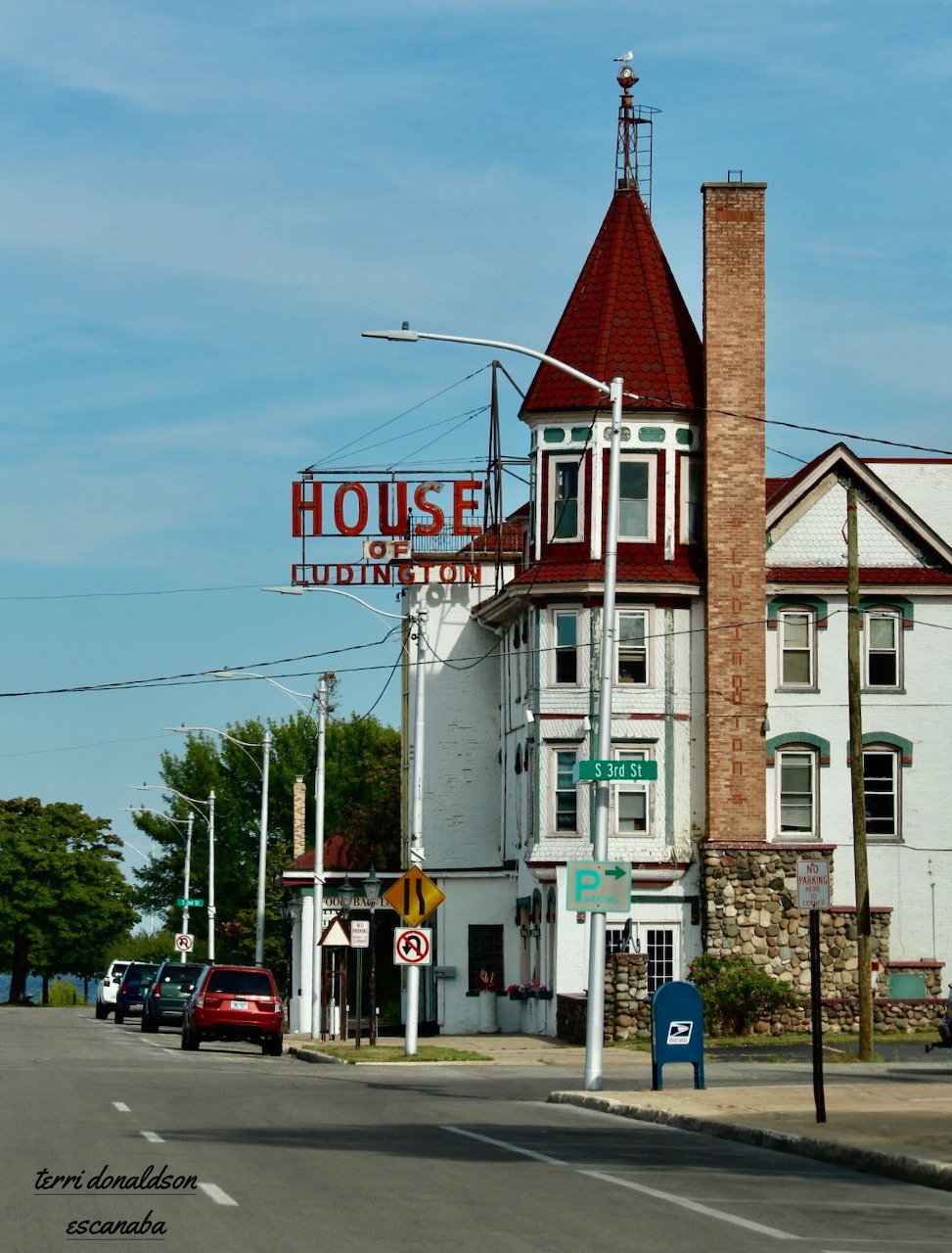 Victorian-style corner building with a red turret beside a street