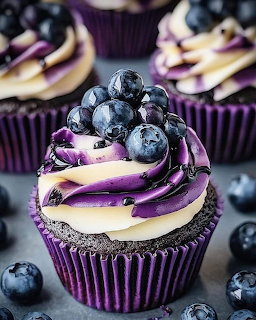 Purple cupcakes with swirled frosting and fresh blueberries on top