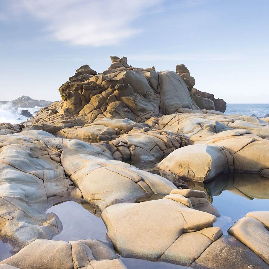 Sculptural rock formation with tidal pools on a coastal beach